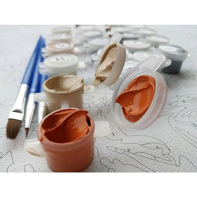 A painting kit featuring various paint tubes and brushes arranged neatly on a wooden table.